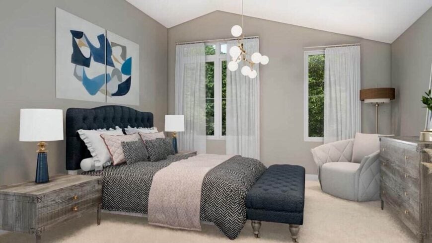 Primary bedroom with a comfy bench, a matching bench, a gray armchair, and a contemporary chandelier that hangs from the vaulted ceiling.