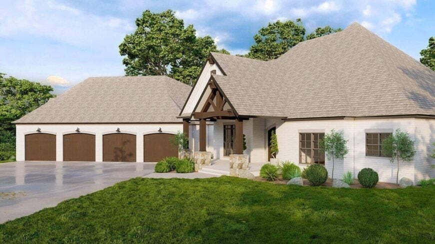 Exposed trusses along with dark wood columns set on stone bases frame the covered entry porch.