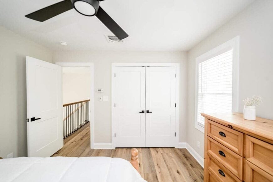 The bedroom includes a walk-in closet concealed behind white double doors.