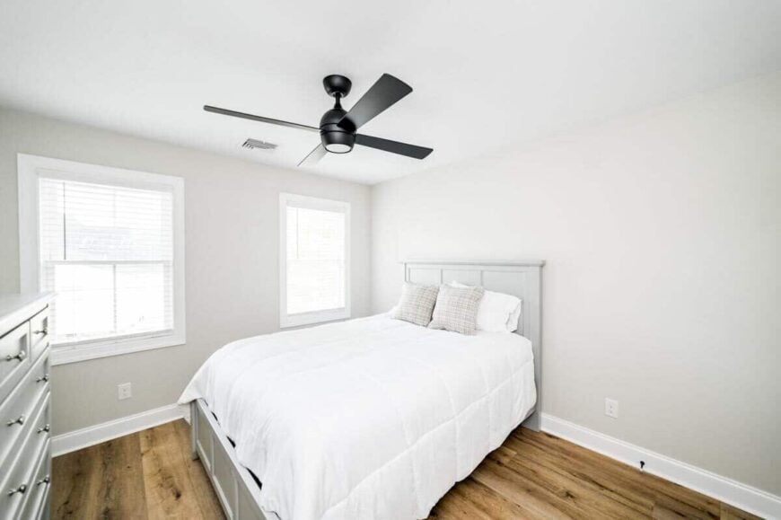 Another bedroom with hardwood floor and gray furnishings that blend in with the walls.