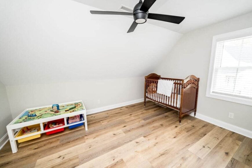 The flex room serves as a nursery and playroom. It has a vaulted ceiling and wide plank flooring.