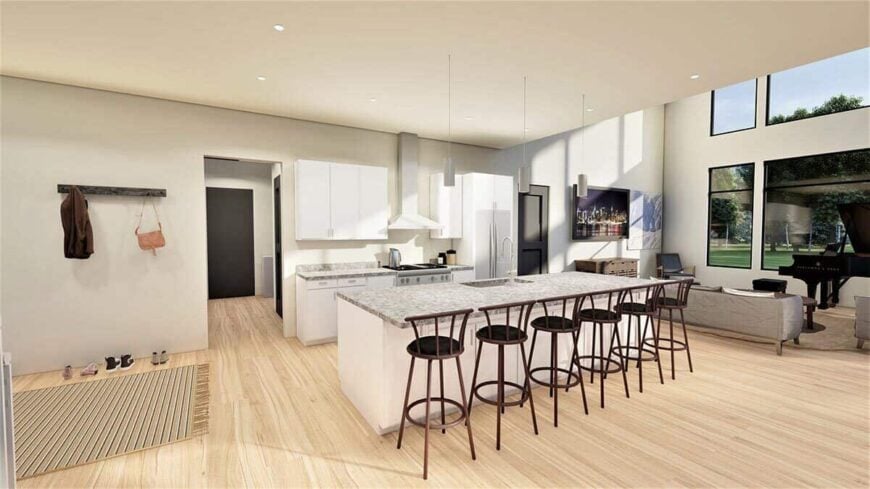 The kitchen has granite countertops, white cabinets, and a lengthy breakfast island paired with round bar stools.