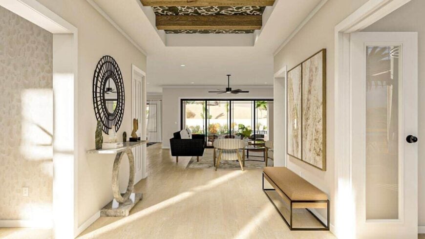 Foyer with a cushioned bench, a marble console table, and beige walls adorned with framed artworks and a decorative round mirror.