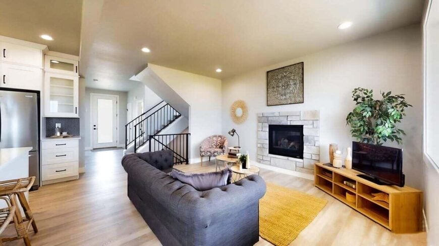 Living room with a chesterfield sofa, a glass-enclosed fireplace, and a TV that sits on a wooden console table.