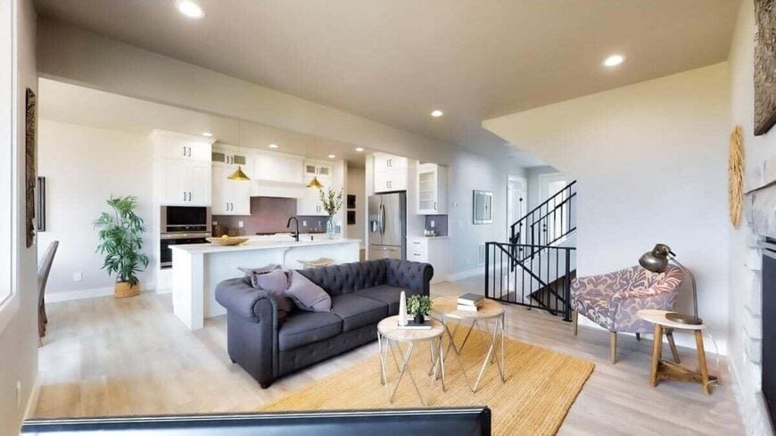 A jute area rug defines the living room while a center island creates distinction to the kitchen.