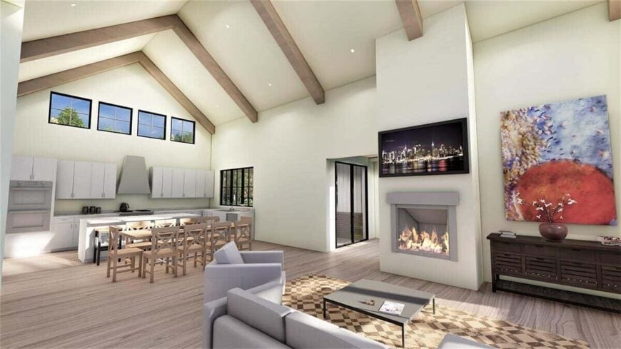 An open layout view of the great room, dining area, and kitchen under a cathedral ceiling.