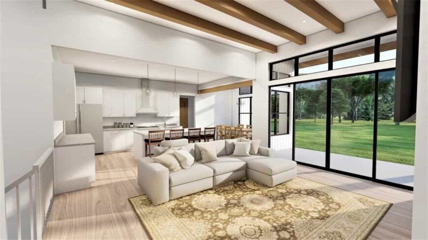 The great room defined by a beamed ceiling opens completely to the kitchen and dining area.