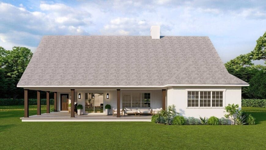 Rear rendering with a covered porch and a tiled roof topped with a chimney.