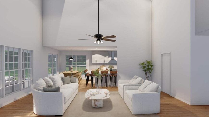 The great room includes gray seats and a marble coffee table sitting on a beige area rug.