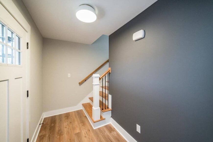 Home entry with two-tone gray walls and a staircase leading to the upstairs bedrooms.