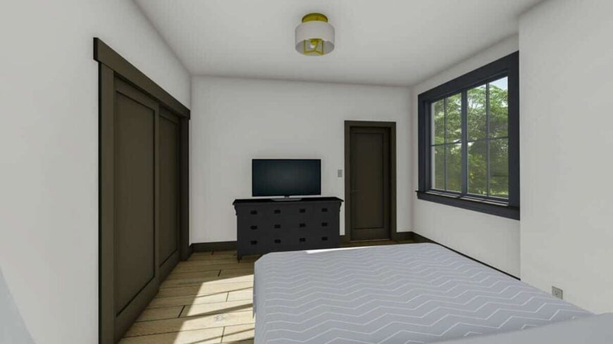 This bedroom mimics the second bedroom with its dark wood furnishings, a TV, and wide plank flooring.
