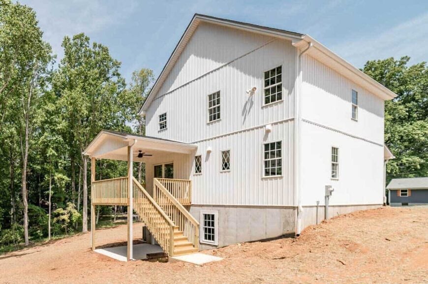 Rear exterior view showcasing a covered deck complemented with a wooden staircase.