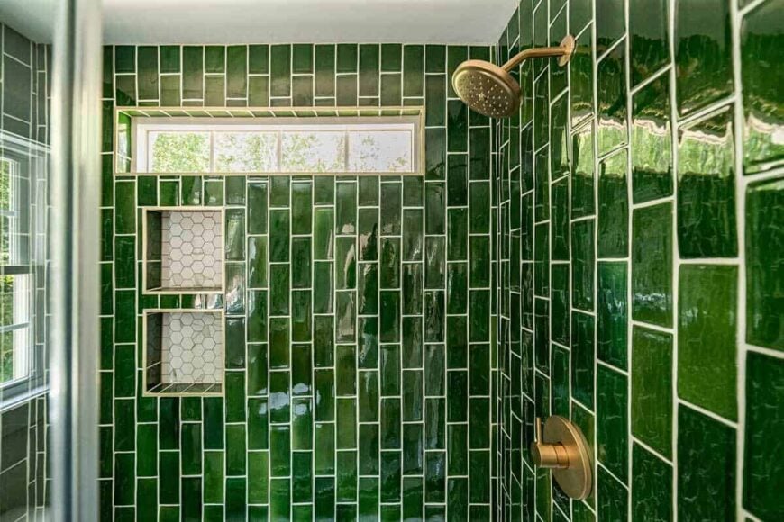 A closer look at the walk-in shower with chrome fixtures, inset shelves, and a clerestory window.