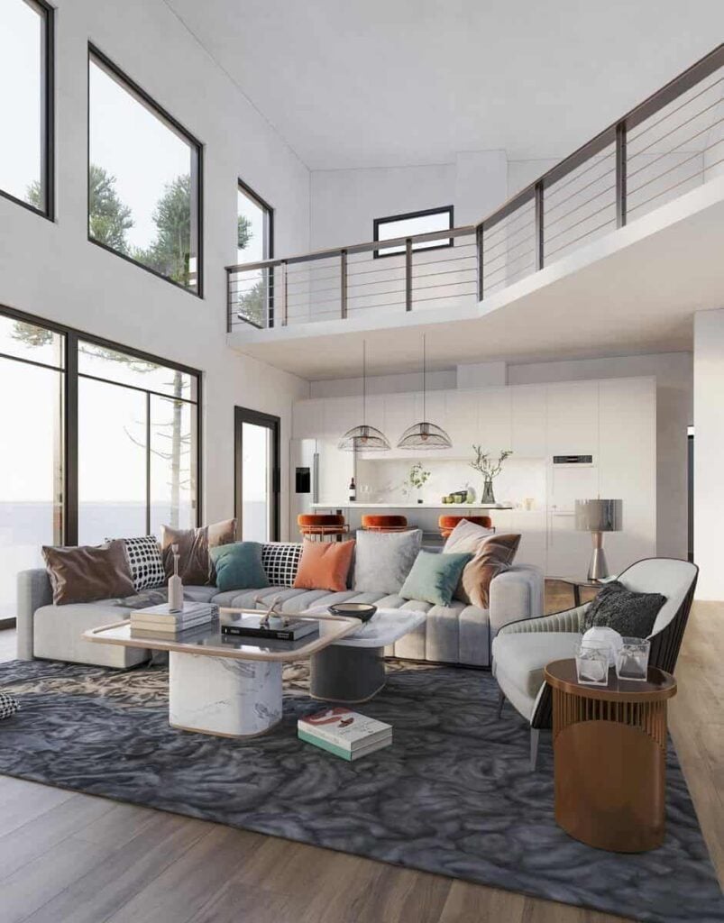 The great room has an L-shaped sofa, a cushioned armchair, and marble tables over a large area rug.
