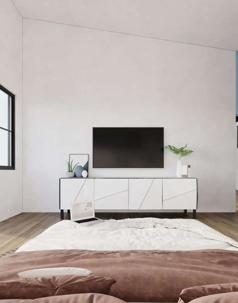 The primary bedroom includes a large TV mounted above the modern console table.