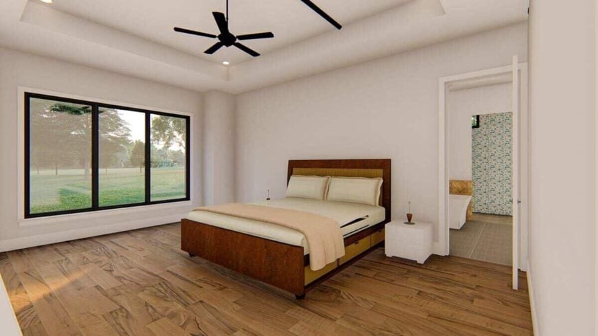 The primary bedroom has a tray ceiling, a cozy wooden bed, and a trio of windows that look out the backyard.