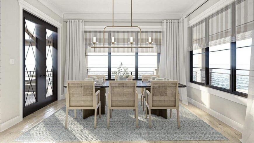 Dining room with a wooden dining set, deck access, and surrounding windows overlooking the magnificent lake.