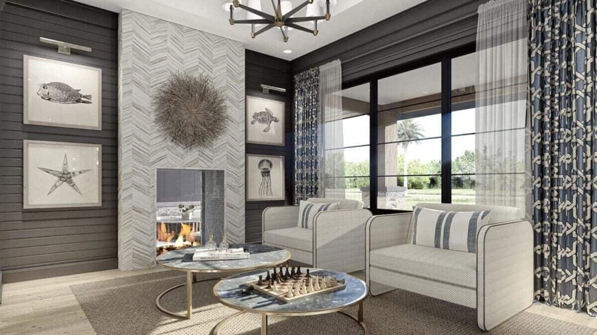 Living room with a double-sided fireplace and contemporary armchairs paired with nesting round tables.