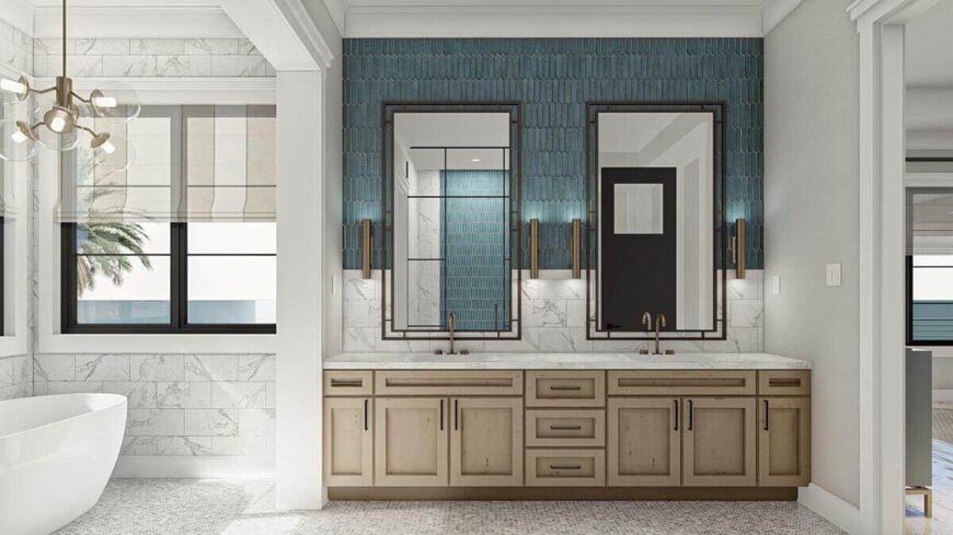 Primary bathroom with a freestanding tub and a wooden vanity equipped with double sinks, a marble countertop, and decorative mirrors.