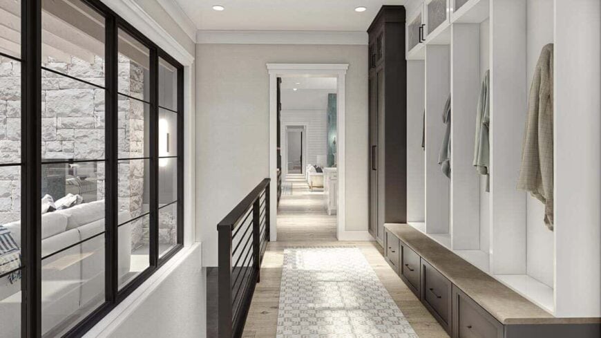 The mudroom is filled with built-in lockers and a bench along with a staircase leading down the basement.