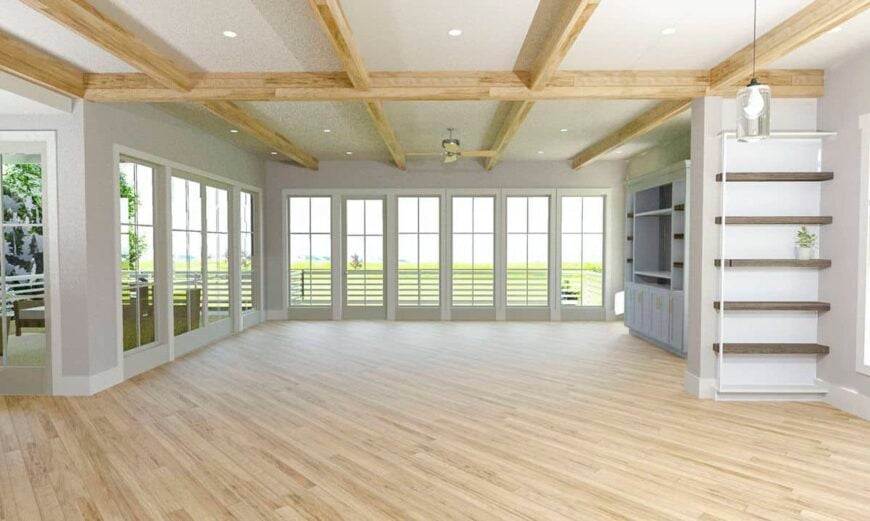The living room features a beamed ceiling, built-in cabinets, and surrounding windows that invite ample natural light in.