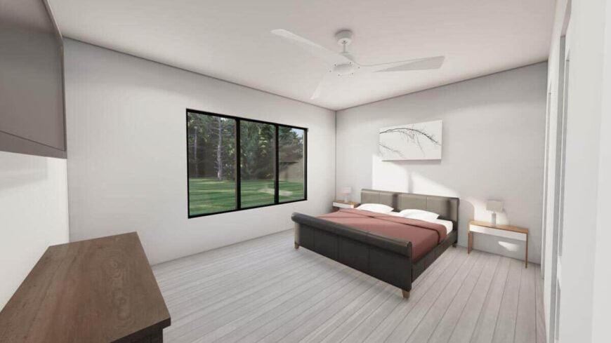 Primary bedroom with hardwood floor, a leather upholstered bed, and a trio of windows overlooking the lush backyard.