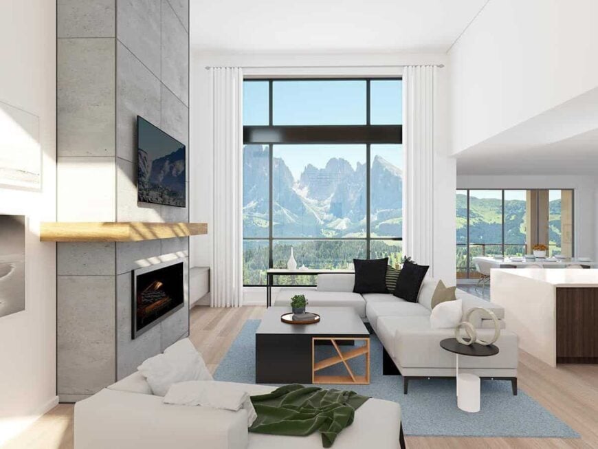 An open living space with a tall ceiling and massive windows that provide stunning views of the surrounding landscape.