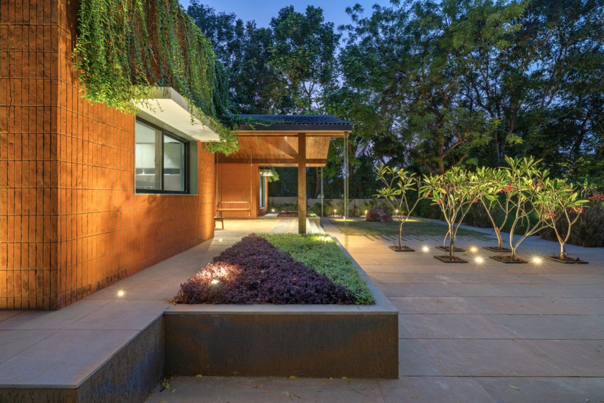 The house exterior walls with lovely fall of vernonia creepers acting like green drapes against the brick surface.