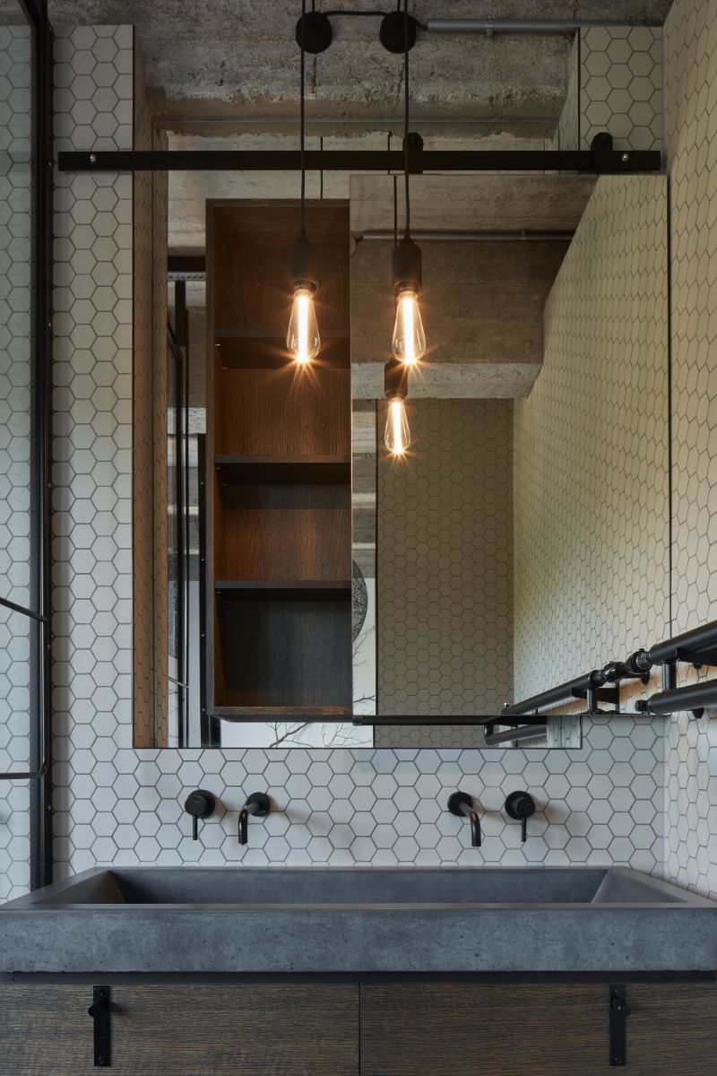 The concrete vanity top with with a matt ceramic mosaic walls.