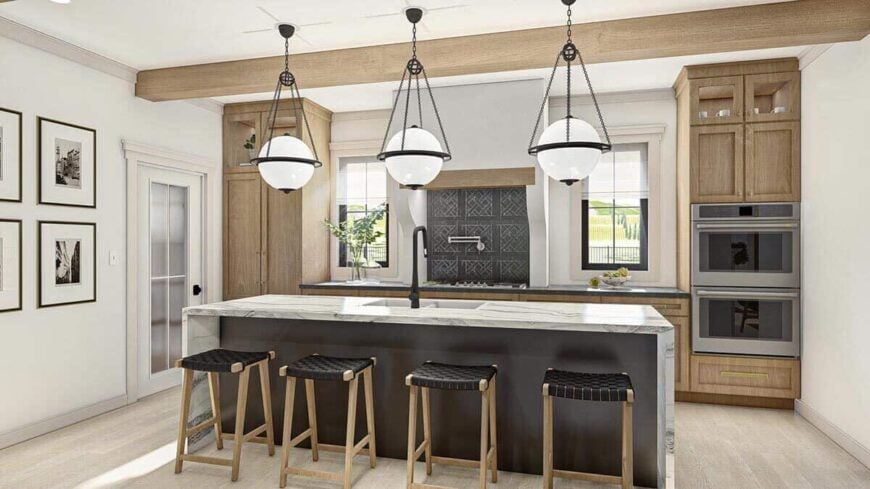 Kitchen with natural wood cabinets and a waterfall island fitted with double sinks.