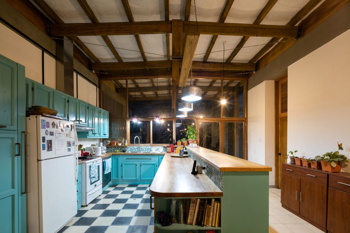 The kitchen area that features beamed ceiling and glass facade window.