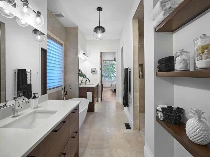 The primary bathroom features his and her sink vanities flanking the freestanding tub.