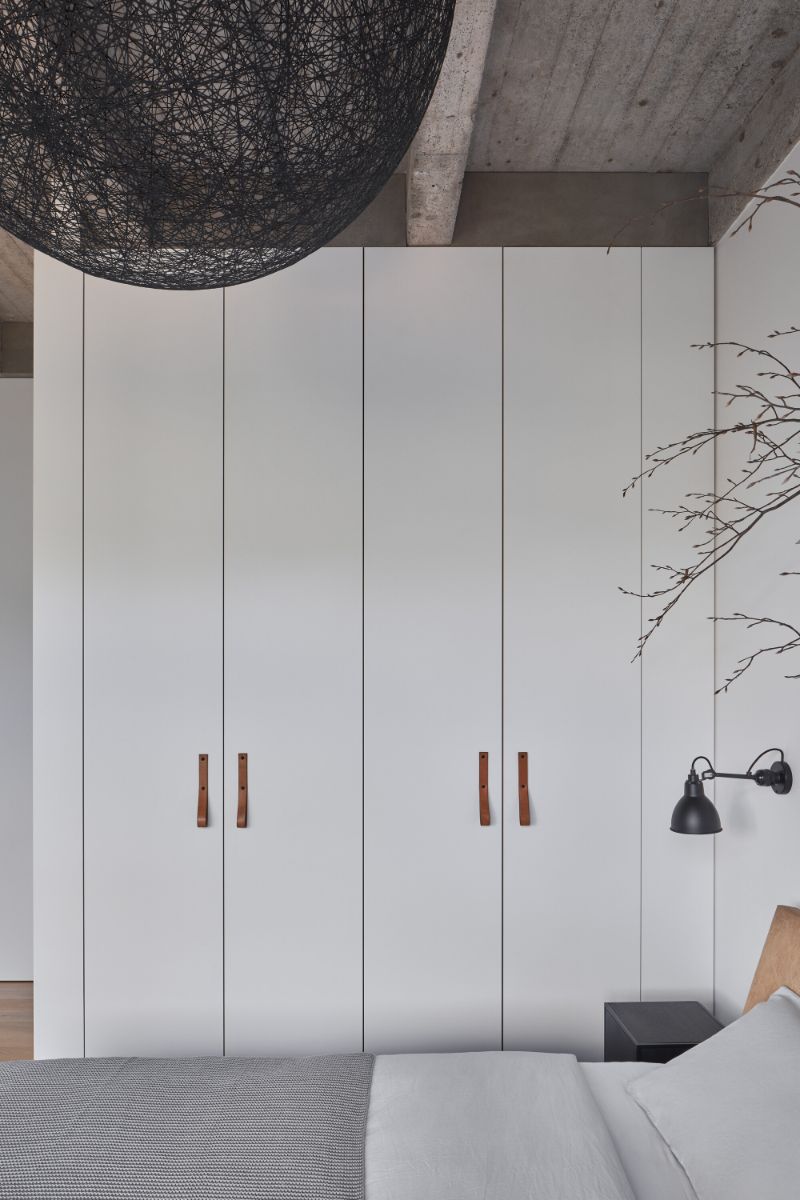 The bedroom with multi-door cabinets in white paint.