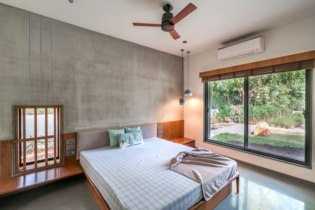 The bedroom with attached bathroom and glass windows.