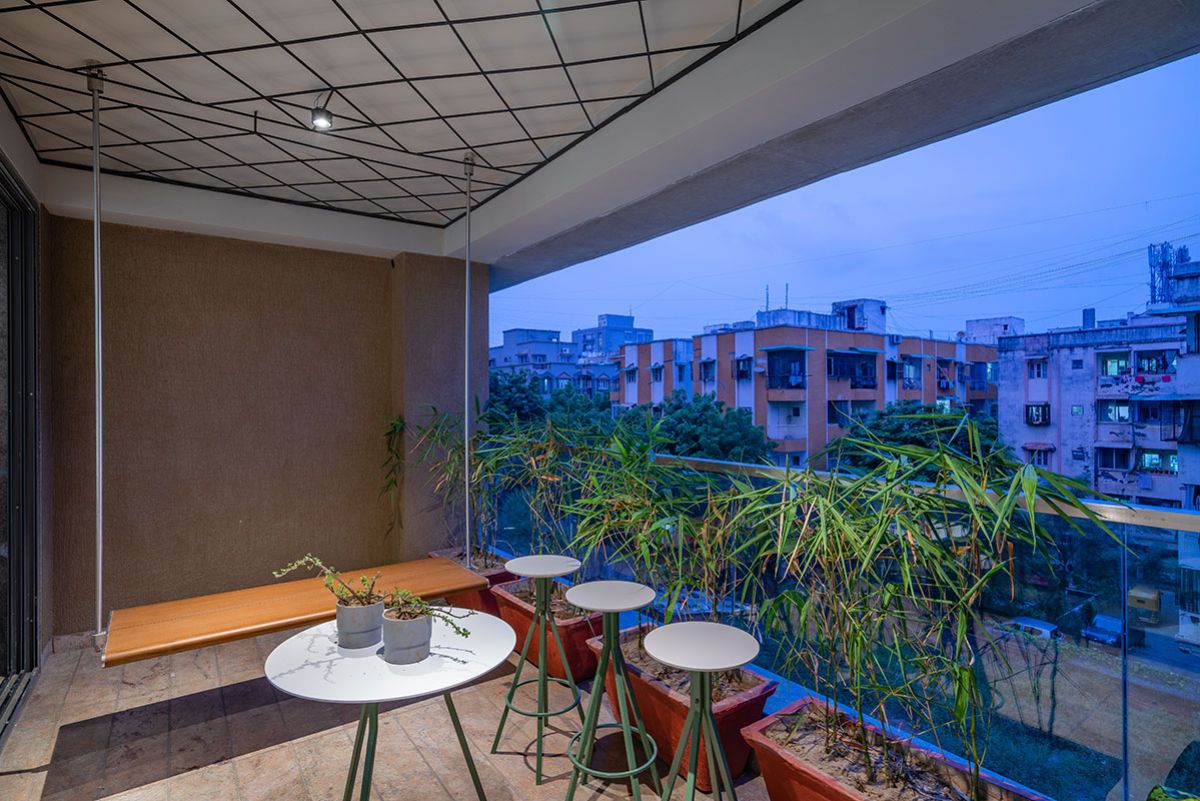 The balcony has tall furniture, so that we can get the borrowed view from the urban fabric around the building.