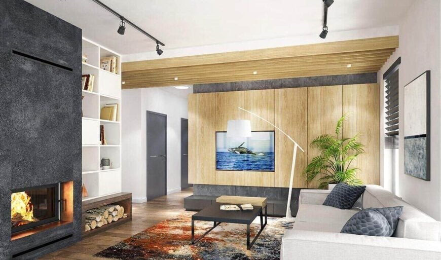 The living room has a fireplace, built-in shelves, a gray sofa, and an iron coffee table sitting on the area rug.