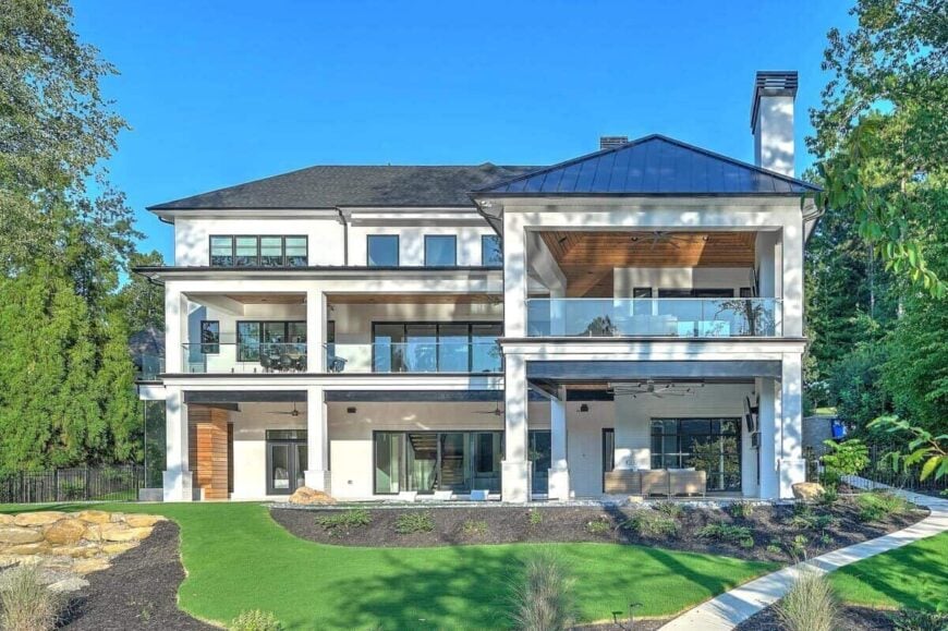 Rear exterior view showcasing its large windows and expansive porches bordered by glass railings.