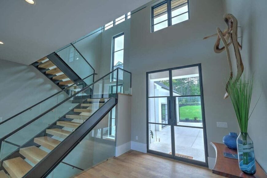 The foyer includes a french front door and a modern staircase leading down the basement and upstairs bedrooms.