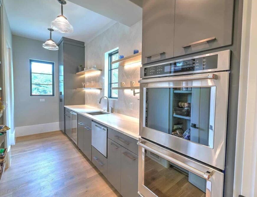 The walk-in pantry is equipped with a double wall oven, wine fridge, an undermount sink, and lots of storage.