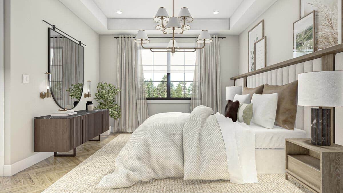 The primary bedroom includes a contemporary console table and an elegant chandelier that hangs from the tray ceiling.
