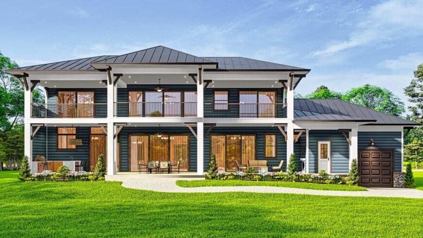 A view of the house from the backyard showcasing the expansive porches framed with white columns and wooden railings.