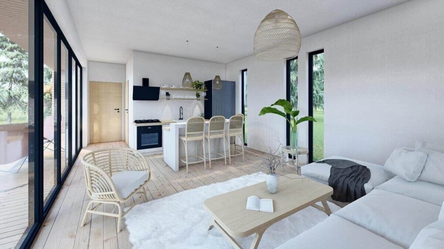 An open layout view of the combined kitchen and living room with wide plank flooring.