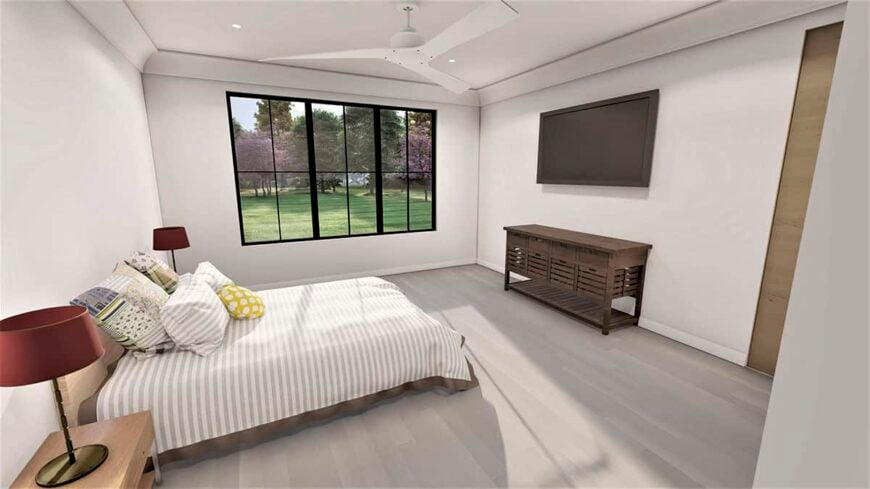 The primary bedroom has a wall-mounted TV and a trio of windows that invite natural light in.