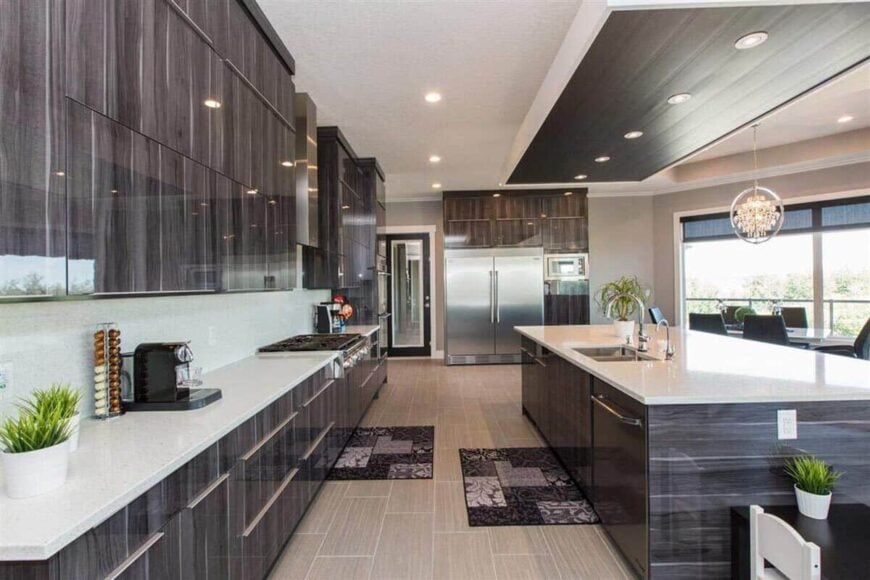 The kitchen is equipped with stainless steel appliances, custom cabinetry, granite countertops, and a large island fitted with double sinks.