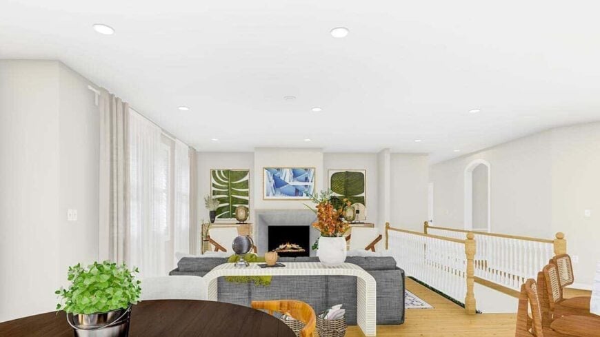 An open living space with a hardwood floor and white walls adorned with framed artworks.