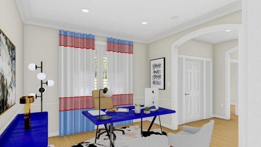 A large archway reveals the home office. It has modern seats and a blue desk that sits on a cowhide rug.