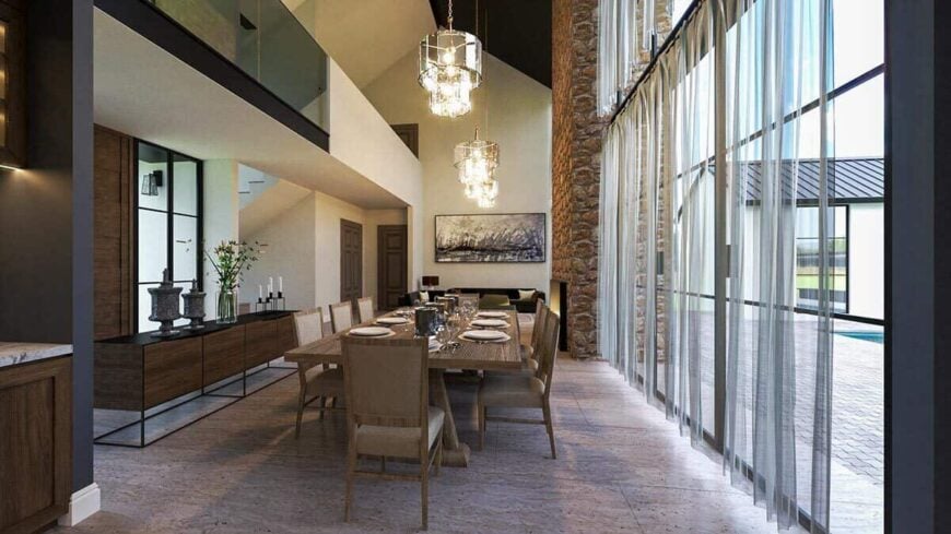Dining room with a buffet table, a wooden dining set, and elegant chandeliers that hang from the cathedral ceiling.