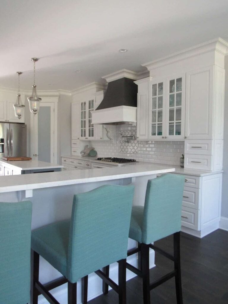 Kitchen with white cabinetry, a center island, and a peninsula with bar seating.