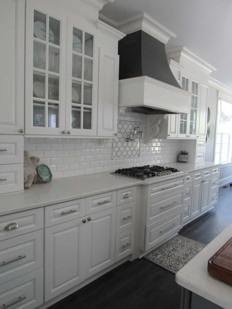 The kitchen includes a built-in cooktop topped with a bespoke vent hood.