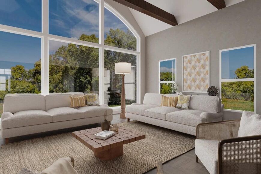 The living room has modern seats, a wooden coffee table over a jute area rug, and huge windows bringing ample natural light in.
